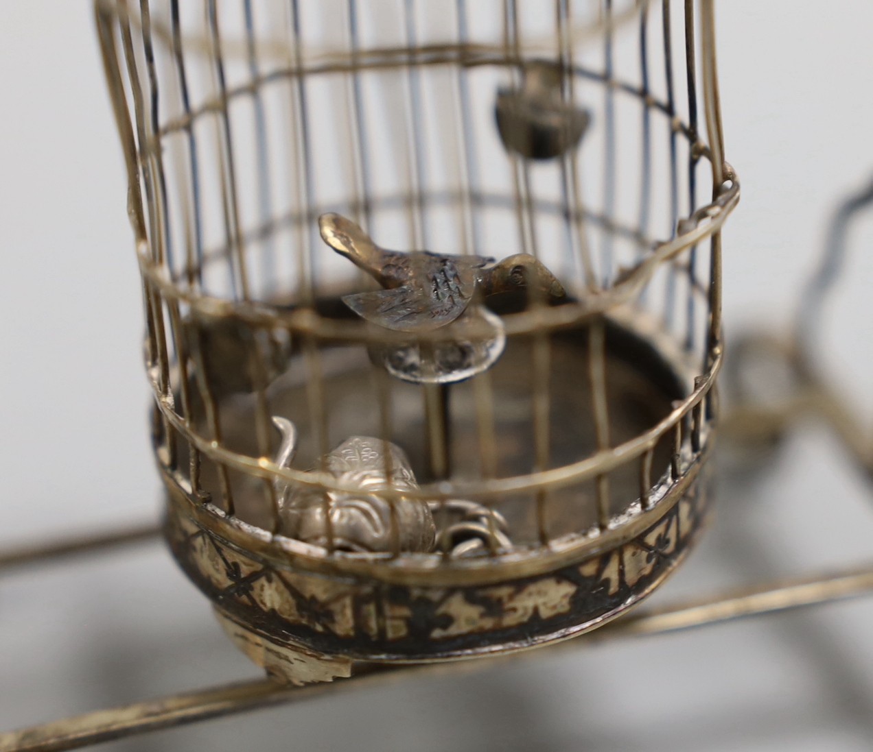A Chinese white metal miniature model of a bird cage and stand, height 11.8cm, and a miniature teapot.